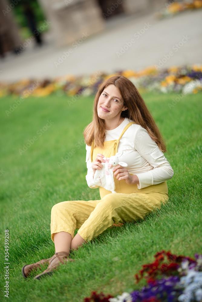 Expecting young female mother posing in park holding plush toy Expecting young female mother posing in park holding plush toy