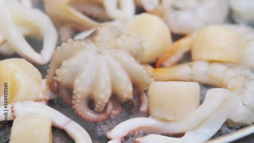 Seafood cocktail in black frying pan. Baby octopus, squid, shrimps, scallop are fried. Seafood cocktail in black frying pan. Baby octopus, squid, shrimps, scallop are fried.