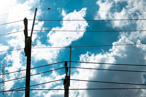 clouds over the sky with electicity pole wire and bird photo