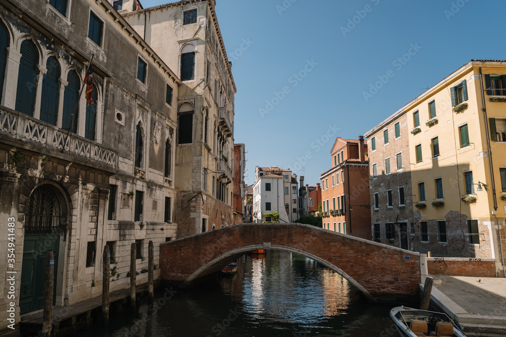 Boats are parked on a deserted canal in Venice, Italy.