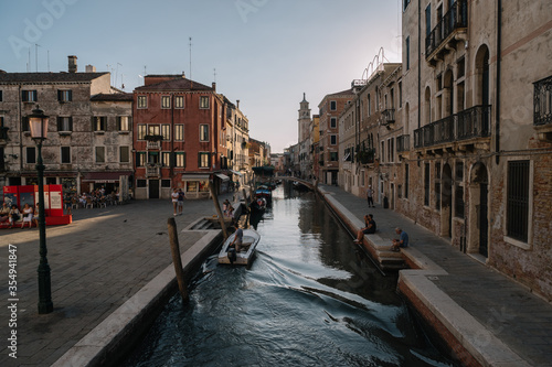 Tourists are resting by the canal of Venice, Italy.