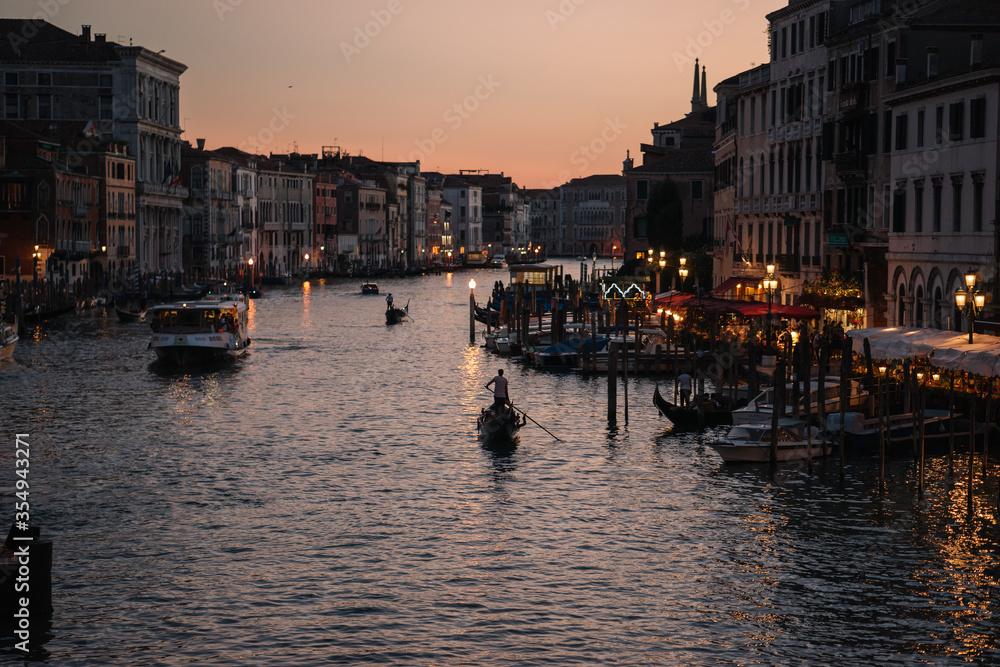 Gondoliers at dusk on the Grand Canal of Venice, Italy.
