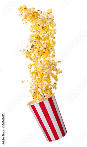 Flying popcorn from paper striped bucket isolated on black background