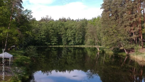 Forest lake in summer surrounded by coniferous green trees, a place to relax.  Aerial photography.