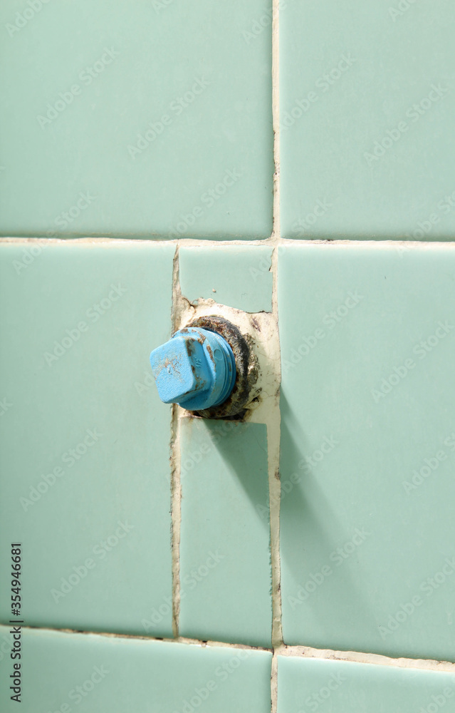 Plumbing steel dilapidated old rusty pipe on green tiles wall. Plumbing steel dilapidated old rusty pipe on green tiles wall.