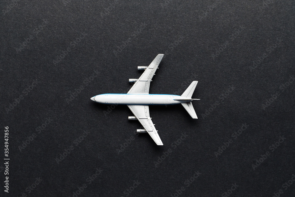 Flight and air transport concept - toy airplane on black background top view. Flight and air transport concept - toy airplane on black background top view.