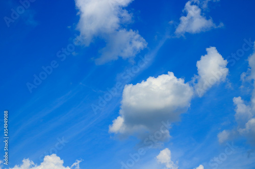 Background with fluffy clouds on bright blue sky