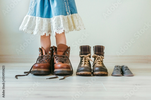 Wooden toys, clothes and shoes on green background photo