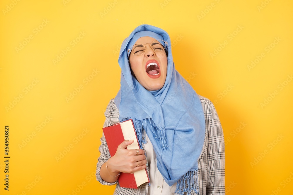 Stressful young muslim woman wearing hijab screams in panic, closes eyes in terror, keeps hands on head, finds out terrified news or disaster, can't believe it. People, stress, annoyance Stressful young muslim woman wearing hijab screams in panic, closes eyes in terror, keeps hands on head, finds out terrified news or disaster, can't believe it. People, stress, annoyance