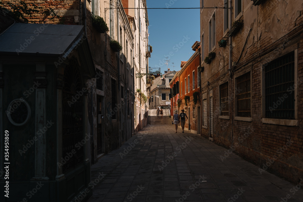 People are walking on the street of Cannaregio district in Venice, Italy.