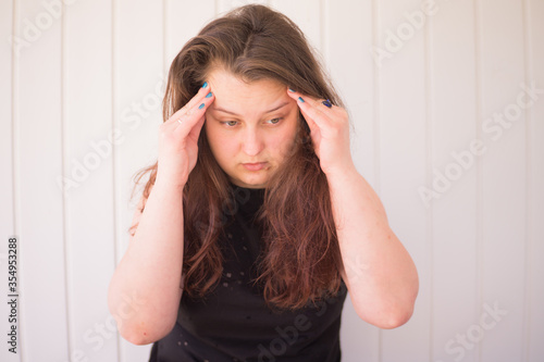 The young girl is upset and holds on to whiskey because of a pain in her head, because her psychological state is stressful.