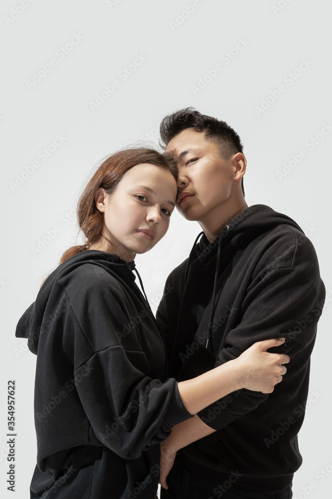 Support. Trendy fashionable couple isolated on white studio background. Stylish woman and man posing in basic minimal stylish clothes equally suitable for both. Concept of equality, inclusive. Support. Trendy fashionable couple isolated on white studio background. Stylish woman and man posing in basic minimal stylish clothes equally suitable for both. Concept of equality, inclusive.
