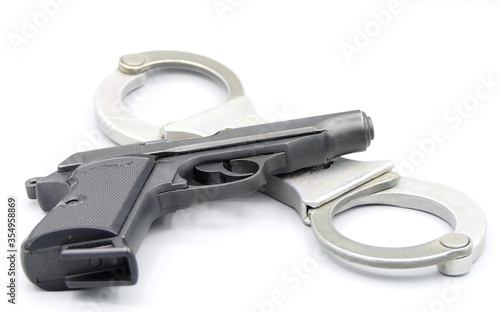 Gun and handcuffs isolated against a white background