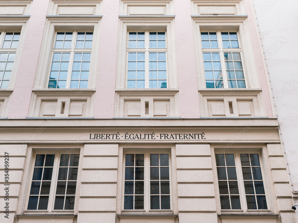 Facade of a historic Parisian building with the national motto of France 
