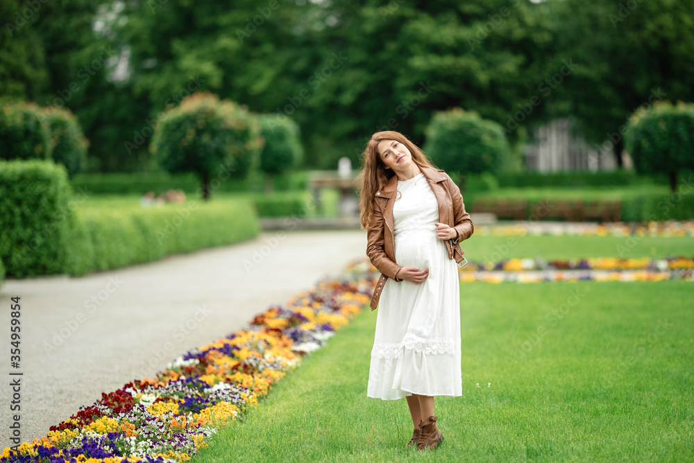 Naklejka premium pregnant brunette woman at an old building gazebo.