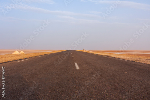 Desert road, dry salt lake Chott el Djerid in Tunisia.