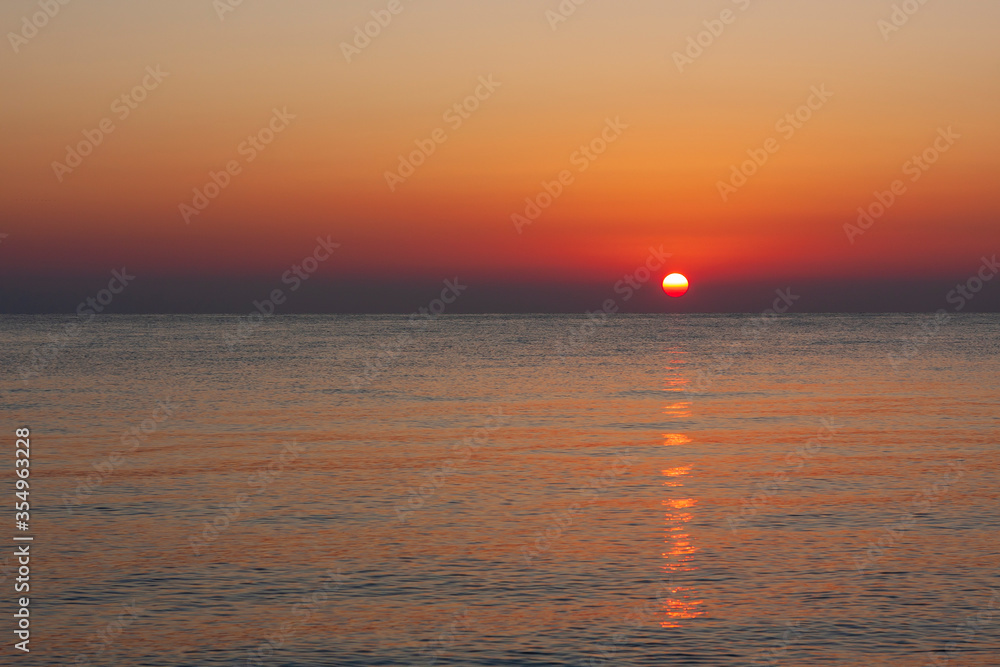 Sunrise on the beach with a view of the sea and the sun