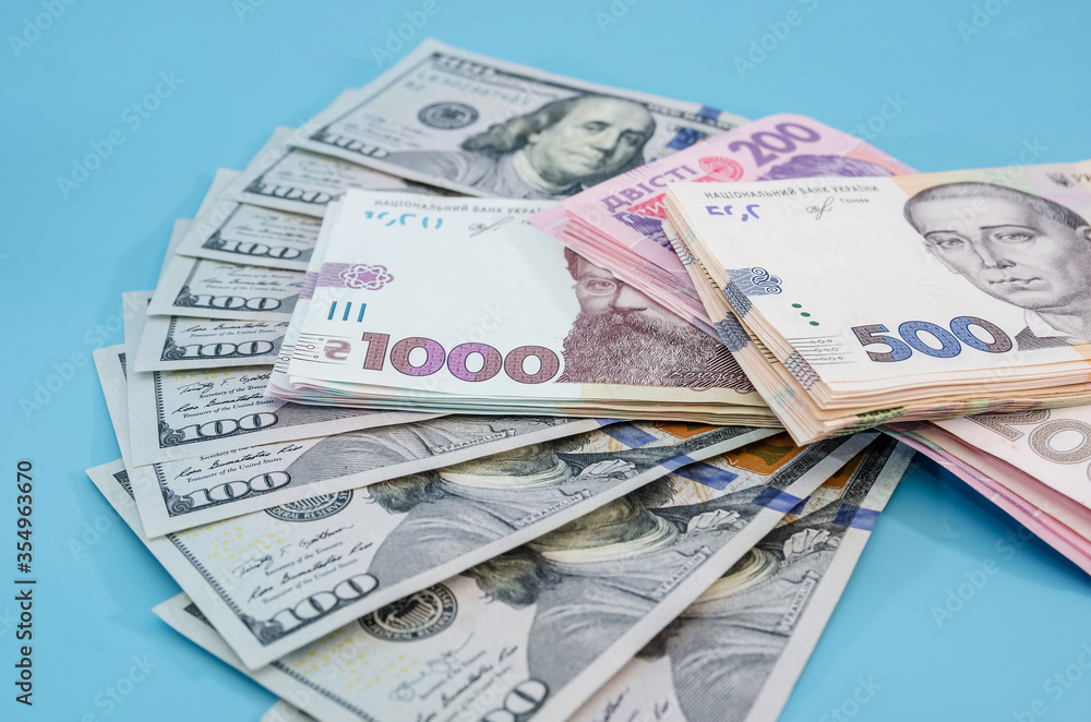 hryvnia and dollars on a blue background, money background. Much money. new banknotes. hryvnia and dollars on a blue background, money background. Much money. new banknotes.