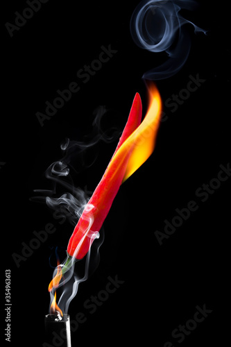 The chilli burned with white smoke floating, showing the hot feeling placed on a black background. photo