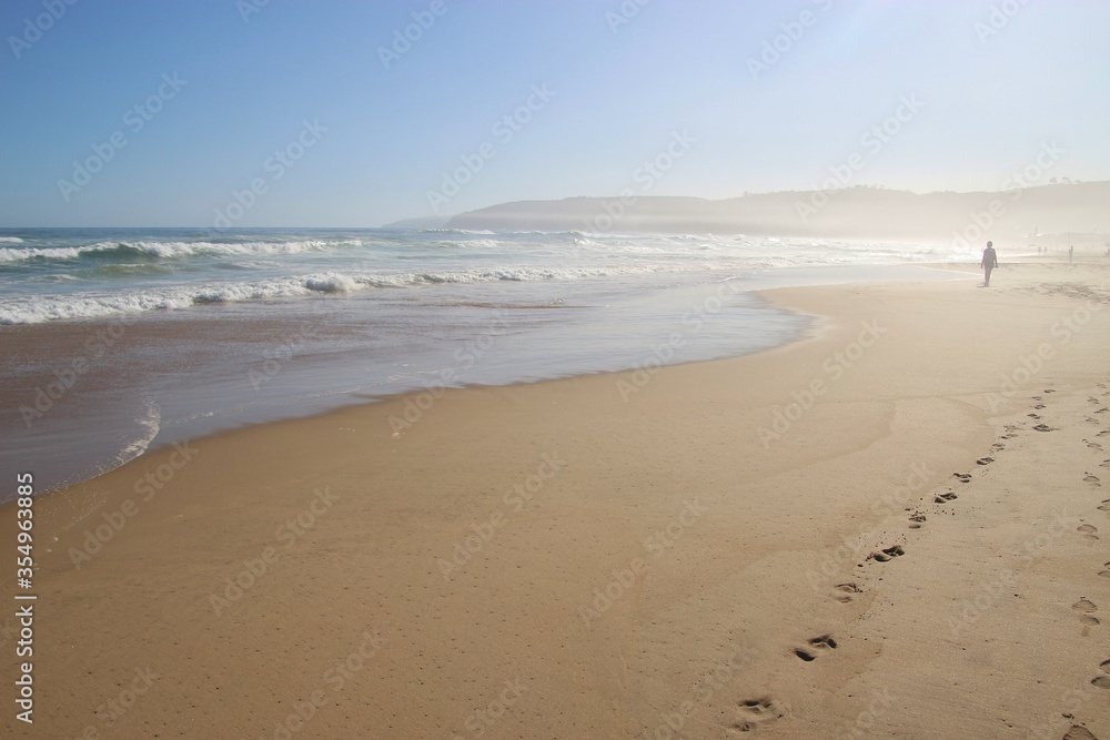 The beach of Wilderness and wild Indian Ocean on Garden Route, South Africa, Africa. The air is dusty because of the strong wind and high surf.