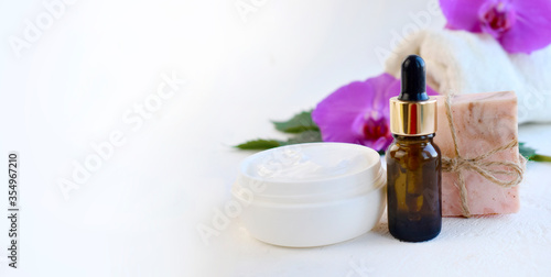 Spa bathe scin care and health still life composition. Essential oil bottle dropper, cream and soap bar over light background. Aromatherapy, organic cosmetic or herbal medicine concept. Copyspace.