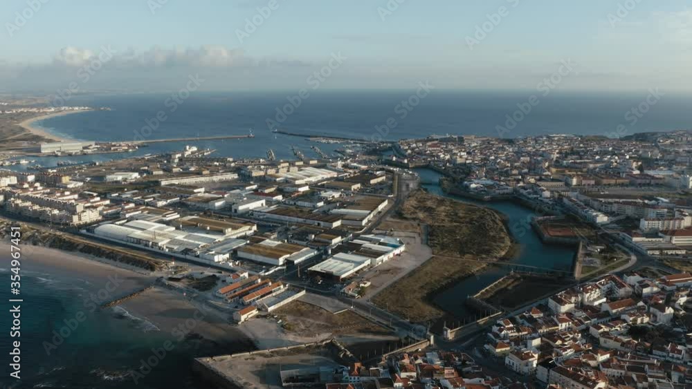Clear aerial view of Peniche's peninsula isthmus featuring both north and south sides of town. Clear aerial view of Peniche's peninsula isthmus featuring both north and south sides of town.