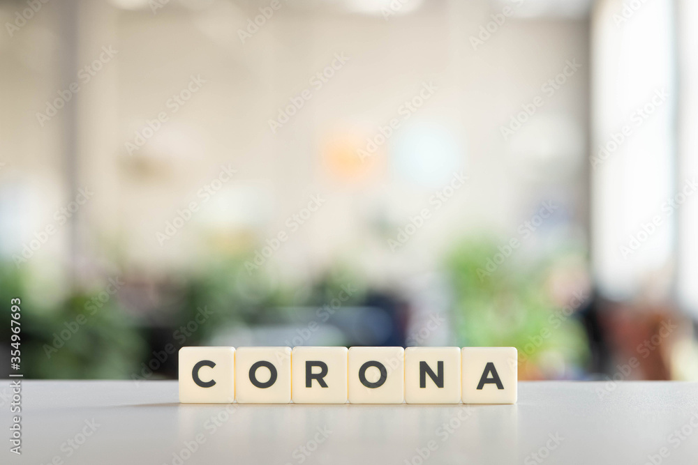 white cubes with corona lettering on white surface, covid-19 concept