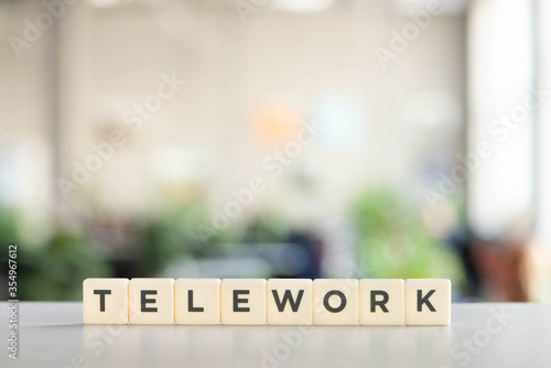 white cubes with telework lettering on white desk photo