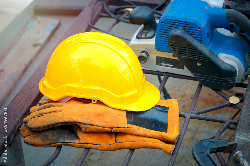 Yellow safety helmet and safety gloves at construction site Yellow safety helmet and safety gloves at construction site