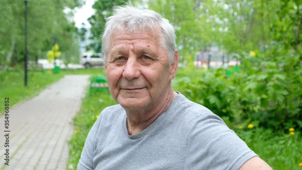 Senior man sitting in park and looking at camera Senior man sitting in park and looking at camera