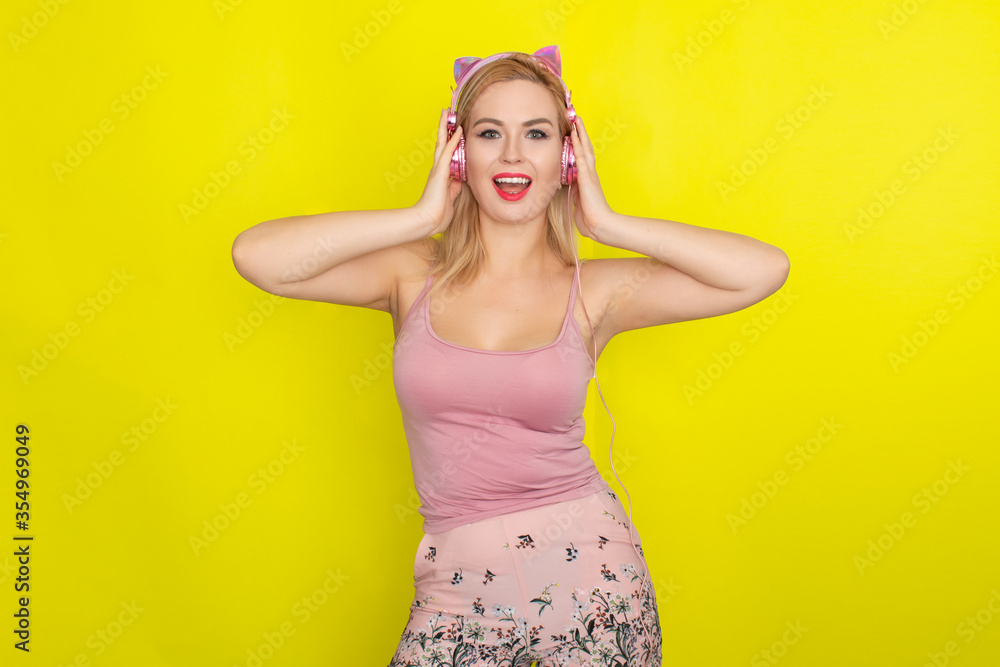 Blonde woman in summer clothing wearing pink headphones Blonde woman in summer clothing wearing pink headphones