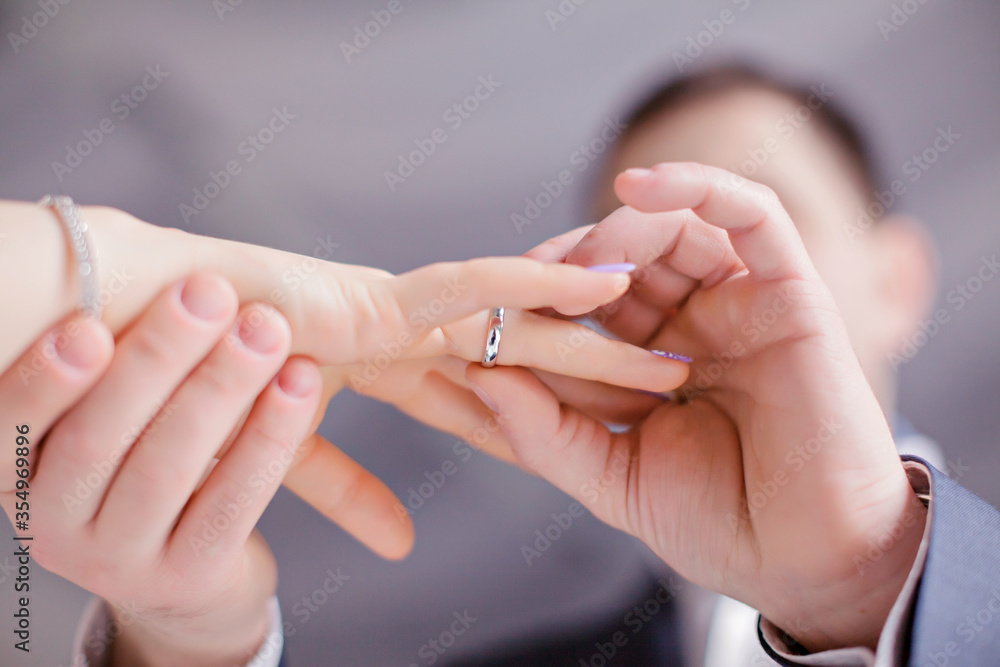 The bride and groom put on each other's wedding rings
