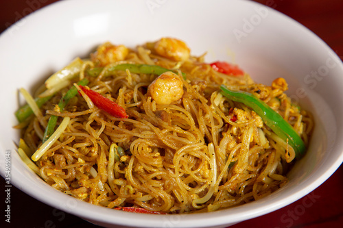 Close-up of bowl of rice curry noodles. Typical oriental dish. Isolated image.