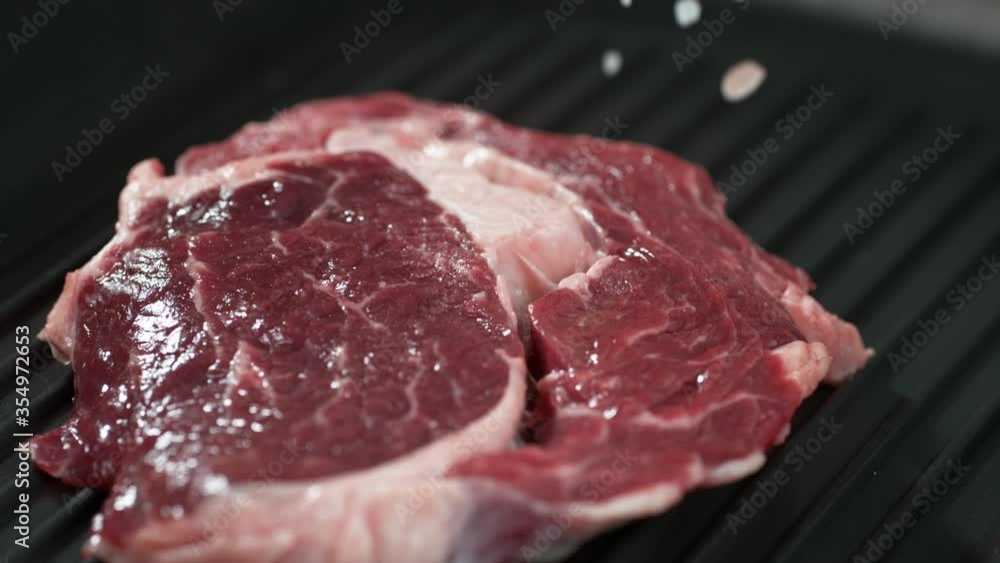 steak meat. Closeup of pork meat falling salt and papper. 4k steak meat. Closeup of pork meat falling salt and papper. 4k