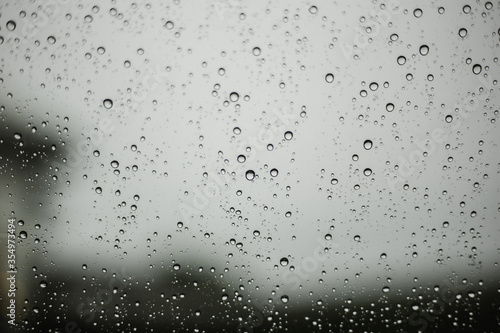 Water droplets flowing through glass