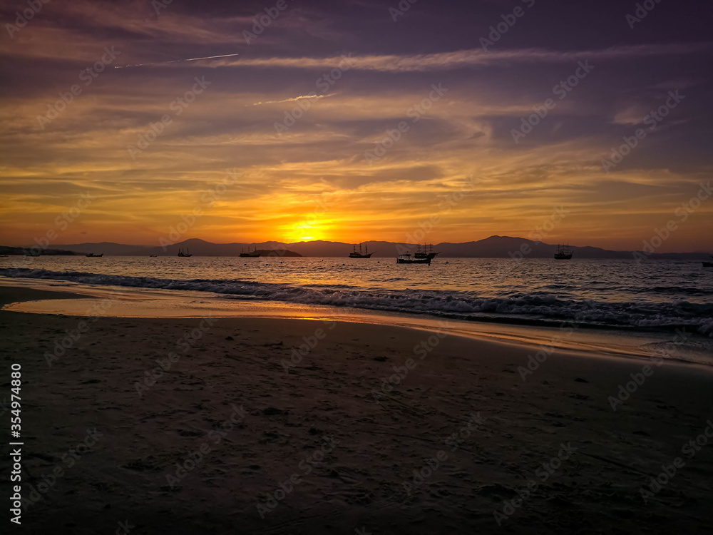 Beach with an incredible sunset where you can see boats and mountains