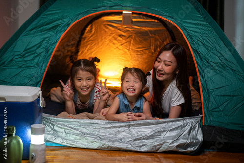 Asian woman playing and staying in tent with her daughter and having fun with camping tent in their bedroom a staycation lifestyle a new normal for social distancing in coronavirus outbreak situation photo