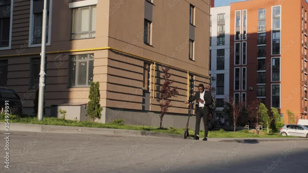 custom made wallpaper toronto digitalAttractive African-American returns from work to home on an electroscooter. Eco transport, care for the environment.