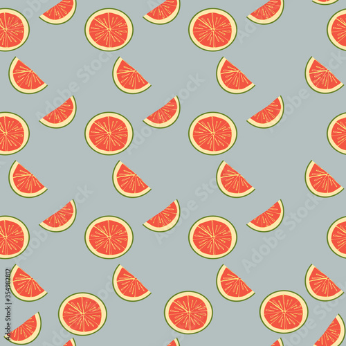 Seamless pattern with the parts, slices, half of a pink grapefruit. Fruit, citrus pattern. Pink fruit on a blue background