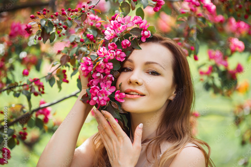 portrait of a beautiful young woman with make-up near a tree with flowers portrait of a beautiful young woman with make-up near a tree with flowers