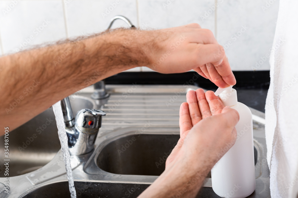 Man washing hands with antibacterial soap and water in metal sink for corona virus prevention. Hand hygiene, health care, medical concept. Hand skin disinfection protect from Coronavirus covid 19 Man washing hands with antibacterial soap and water in metal sink for corona virus prevention. Hand hygiene, health care, medical concept. Hand skin disinfection protect from Coronavirus covid 19