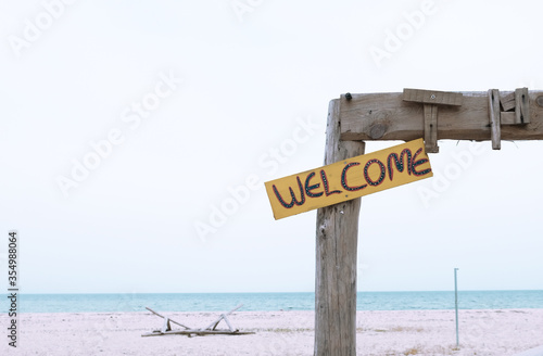 Welcome sign on an empty beach with simplified background isolated