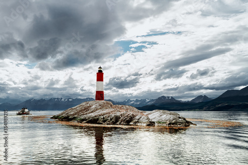 Les Eclaireurs lighthouse on a stone island of the Beagle Channel with catamaran moving away