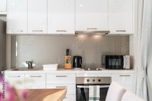 Interior design of kitchen in luxury villa, apartment feature kitchen counter, refrigeratpr, oven, hood and microwave