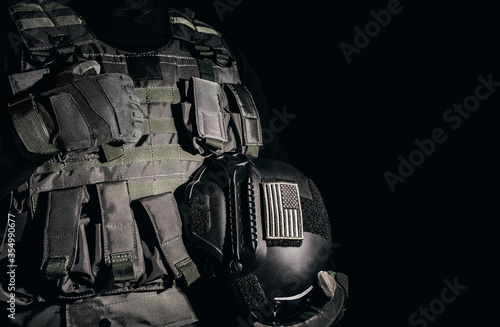 Foto Soldier in armor vest standing and holding helmet with american flag patch