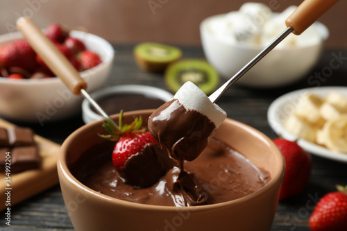 Marshmallow and strawberry in chocolate, close up. Chocolate fondue
