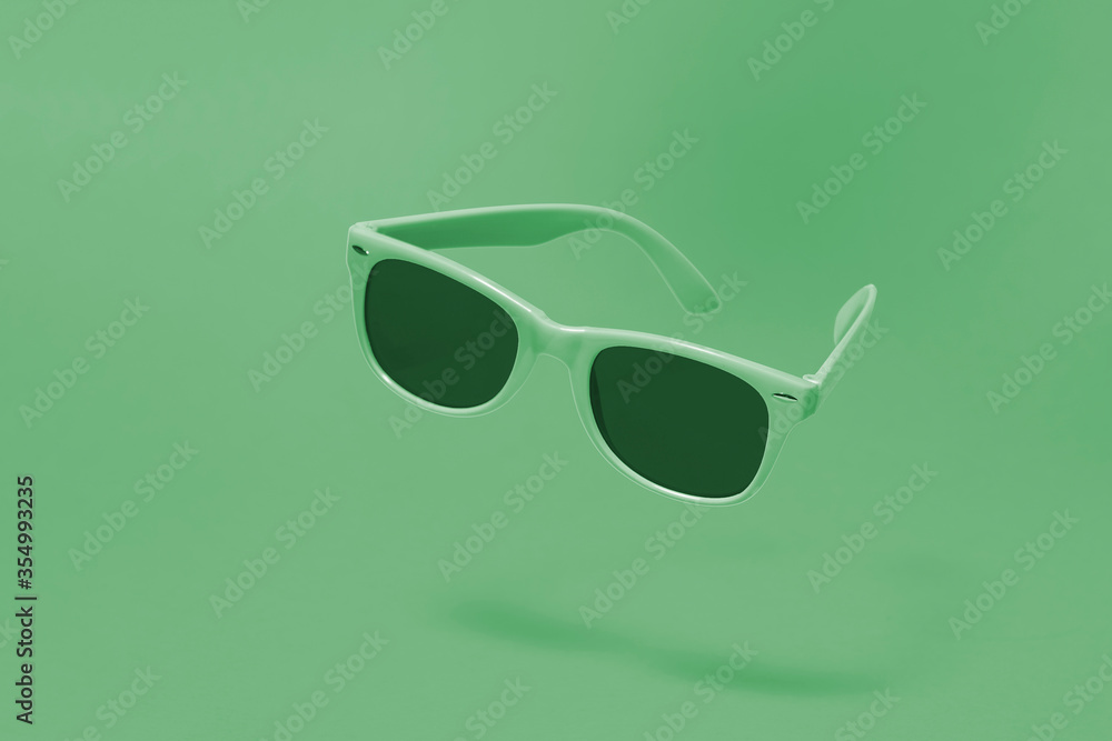 Light green sunglasses floating above a matching light green background with a centre composition Light green sunglasses floating above a matching light green background with a centre composition