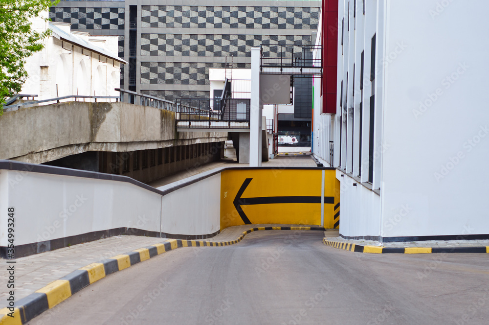 Naklejka premium black arrow pointer to a yellow white wall background