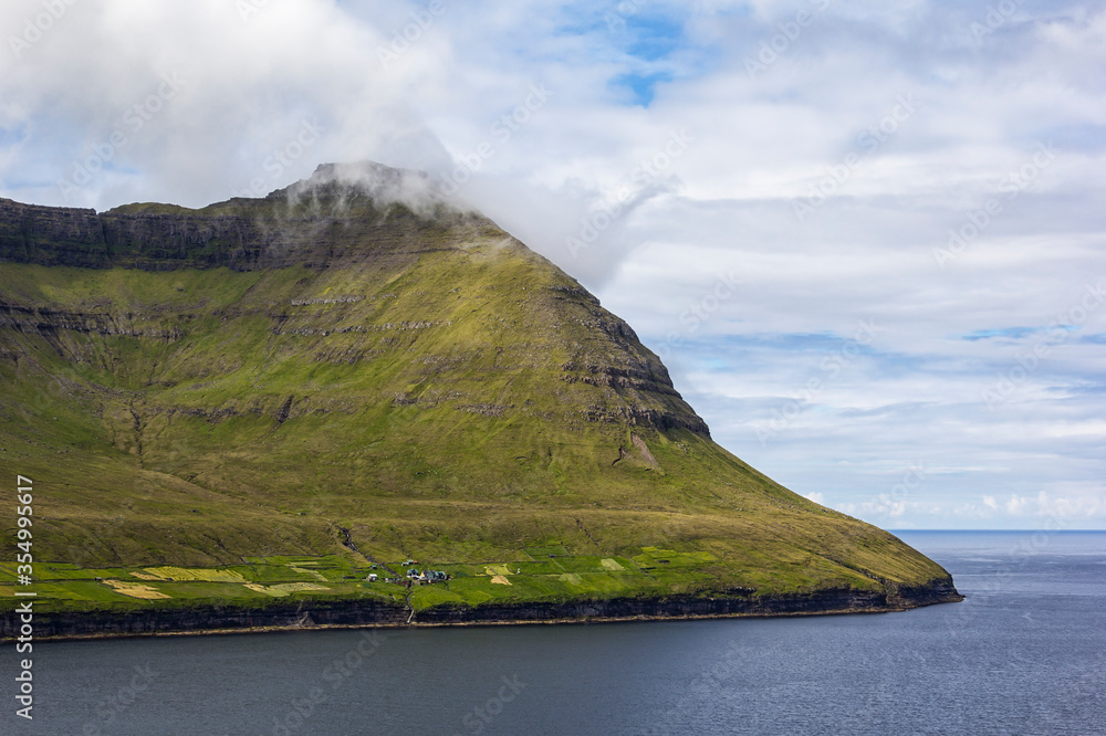High mountains that reach up to the Atlantic Ocean are typical for the landscape of the Faroe Islands.