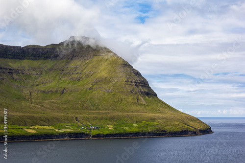 Obraz na płótnie High mountains that reach up to the Atlantic Ocean are typical for the landscape of the Faroe Islands. w salonie